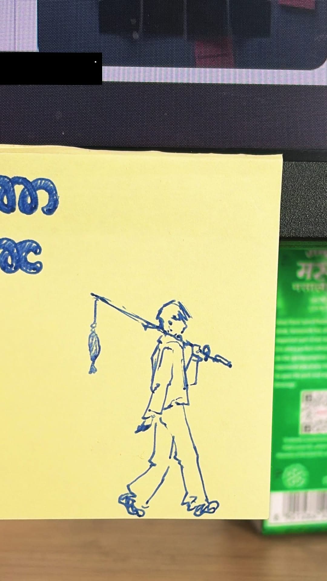 Blue pen doodle of a figure carrying a stick on a yellow sticky note